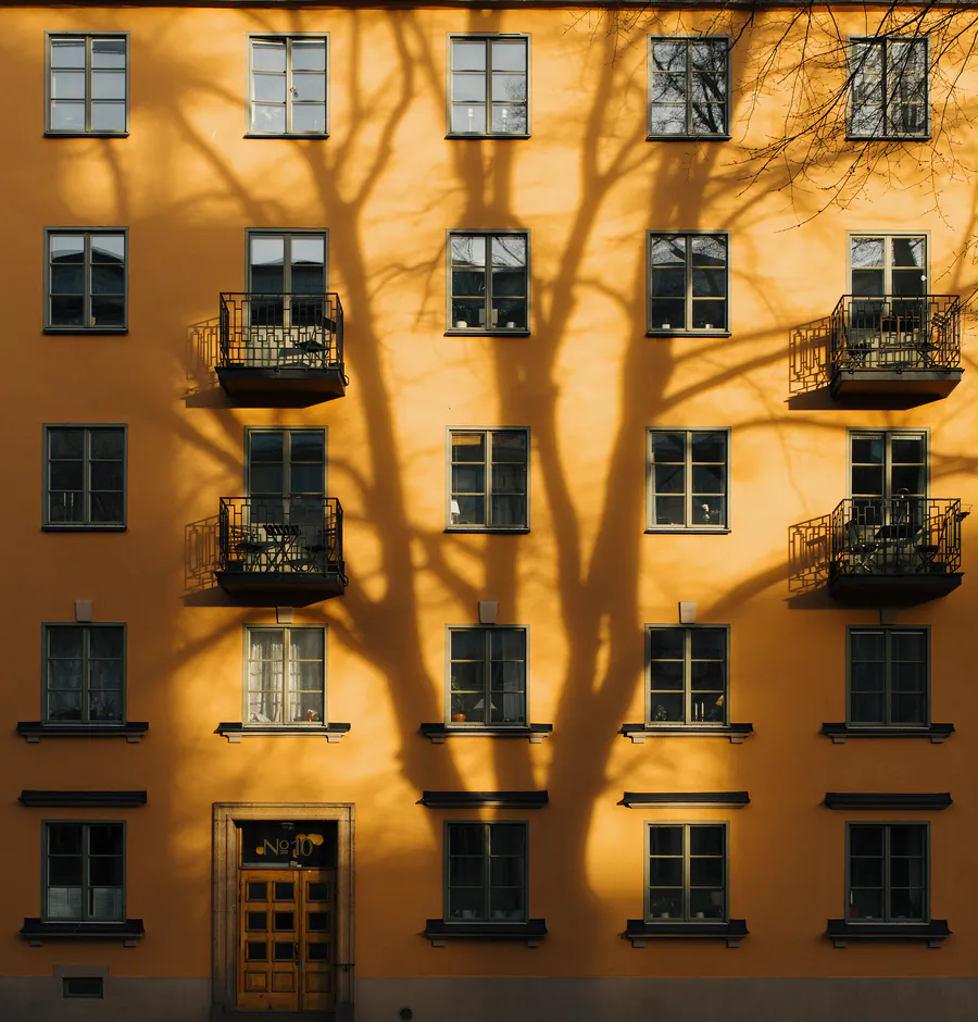 Gul putsfasad med balkonger på ett flerbostadshus på Fridhemsgatan i Stockholm