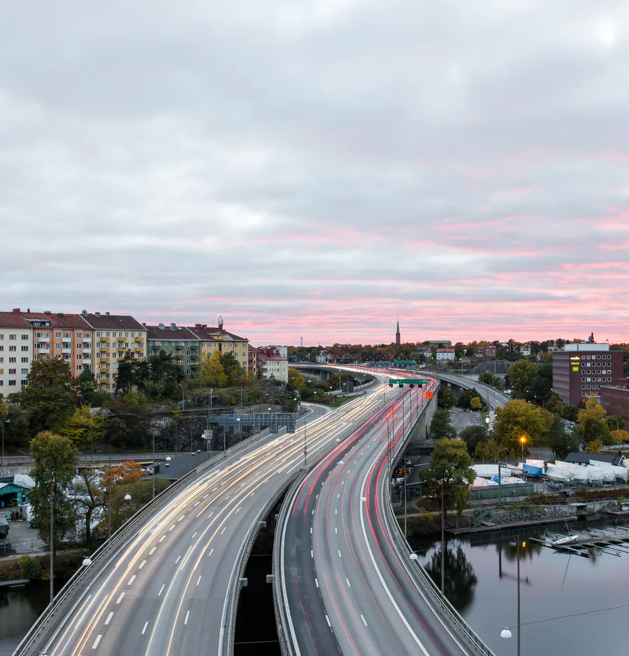 Essingeleden i skymningen med bostadskvarter i Fredhäll och Kungsholmen i bakgrunden